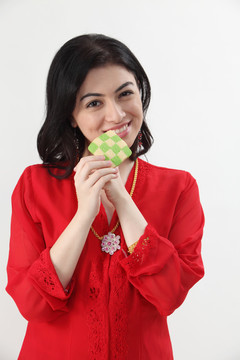 穿着红色凯巴亚的马来女人手里拿着格子饼干