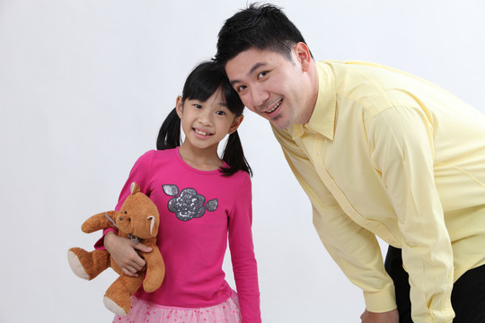 女儿和父亲抱着一只泰迪熊