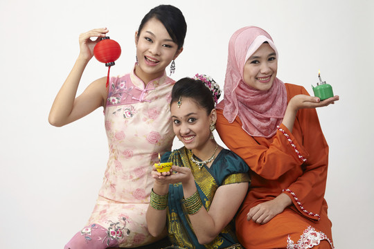 三名马来西亚妇女手持灯笼和油灯