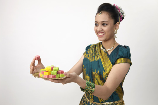 快乐的印度女士提供糖果