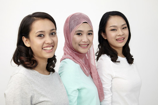 三个不同种族的马来西亚人站成一排看着摄像机
