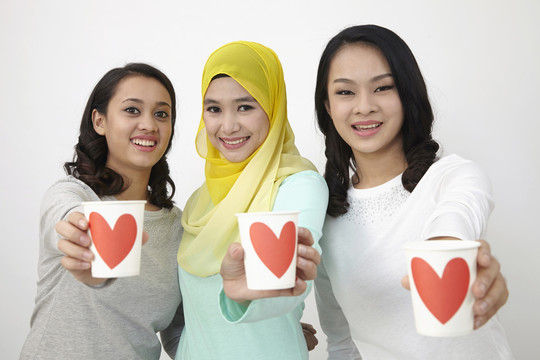 三个多种族的马来西亚人拿着爱的杯子看着镜头