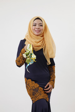 一个马来女人拿着图东展示着一堆凯图帕特