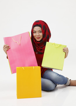 工作室拍摄的马来妇女与图东分享购物袋