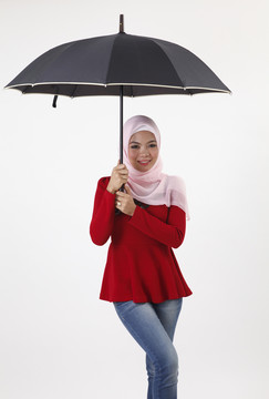 图为手持雨伞的马来妇女的概念照片