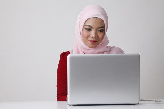 坐在笔记本电脑前的马来妇女