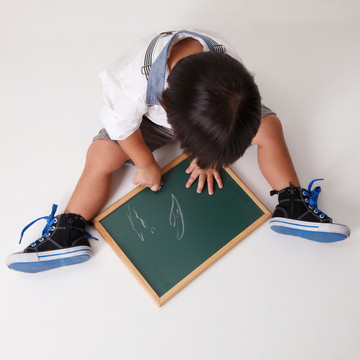 中国男孩在黑板上写字的俯视图