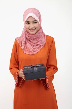 亚洲穆斯林马来妇女拿着礼品盒，白色背景的图东