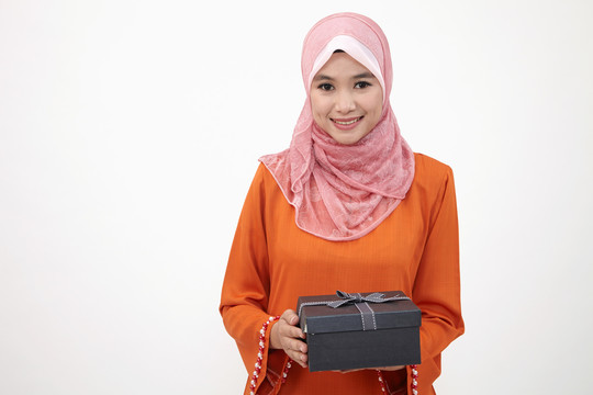 亚洲穆斯林马来妇女拿着礼品盒，白色背景的图东