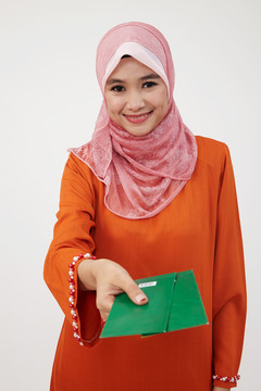 亚洲穆斯林马来妇女拿着绿包
