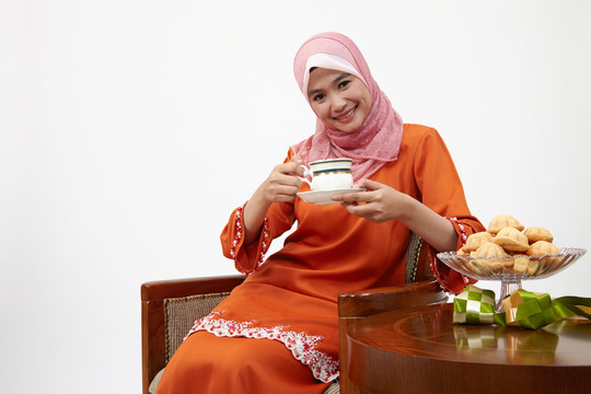 亚洲穆斯林马来妇女与图东一起喝热茶