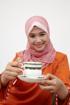 亚洲穆斯林马来妇女与图东一起喝热茶