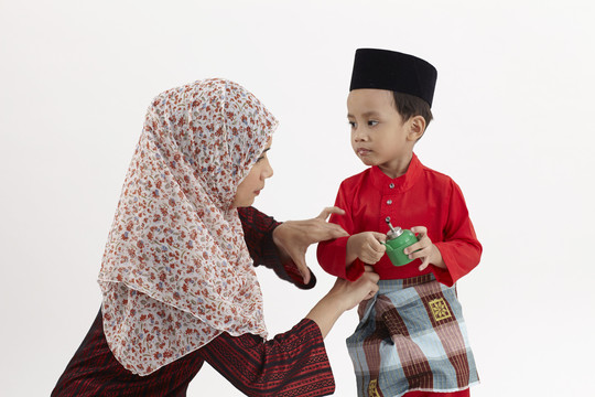 一名马来妇女正在给她的儿子巴朱·拉亚治病
