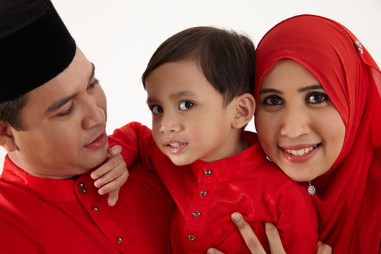 一对马来夫妇抱着他们的儿子