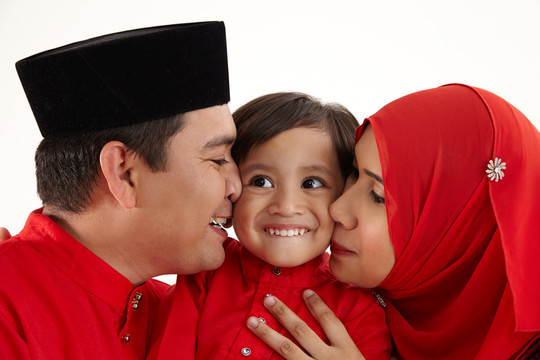 一对马来夫妇抱着他们的儿子