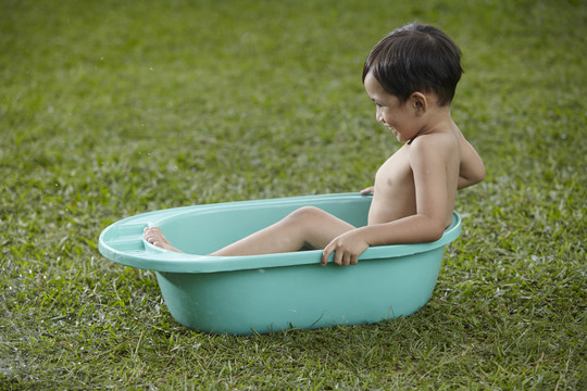 马来男孩在户外洗澡