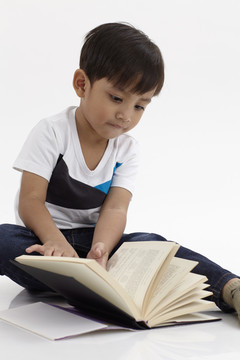 马来男孩坐着看书
