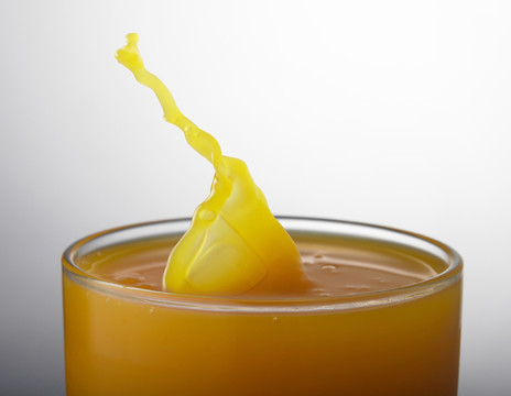 橙汁从玻璃杯里溅出来