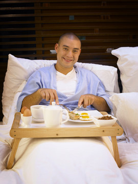 在床上吃早餐的男人