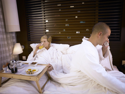 夫妻俩在舒适的床上吃早餐，被电话打断