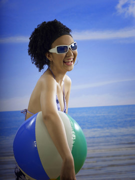 微笑着拿着沙滩球的女人
