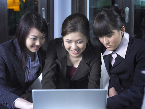 三个女员工在用笔记本电脑