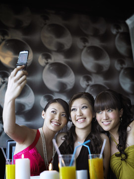 三个女人在餐厅用手机自拍