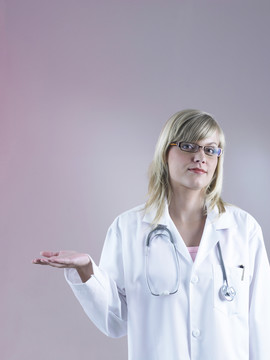 年轻的女医生戴着听诊器，抬起手臂