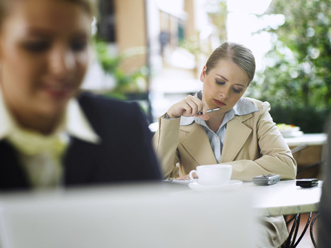 两位商务女性坐在咖啡馆外的选择性聚焦