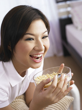 微笑的女士拿着一碗麦片的画面