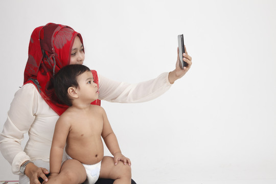 马来妇女抱着儿子一起拍照