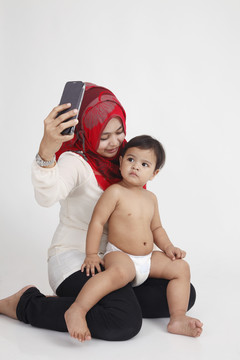 马来妇女抱着儿子一起拍照