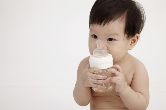 中国女婴抱着奶瓶坐着