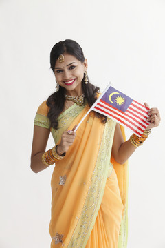 身着迷人传统服装的印度妇女手持马来西亚国旗庆祝活动