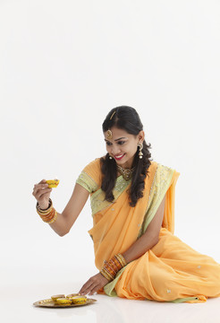 印度妇女，穿着迷人的传统服装，手持油灯