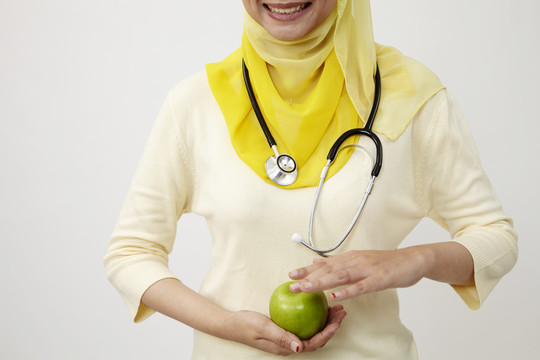 手持青苹果的马来女医生