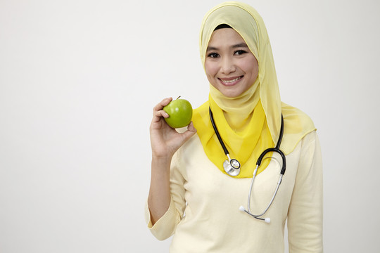 手持青苹果的马来女医生