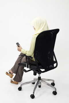 马来女商人使用手机的后视图