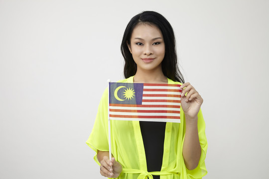 中国妇女举着白色背景的马来西亚国旗