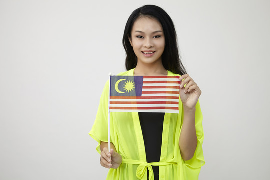 中国妇女举着白色背景的马来西亚国旗
