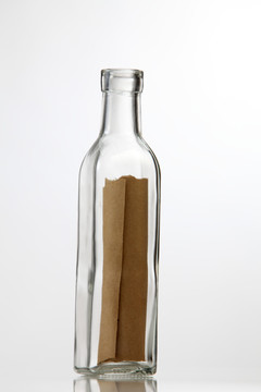 在白色背景的瓶子里放一张棕色的纸