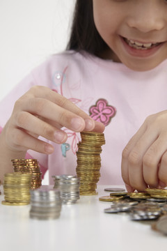 小女孩在桌子上数他的硬币