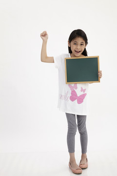 可爱的小女孩拿着黑板，孤零零地站在白色的地板上