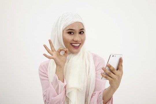一名马来妇女正在用手机读一条写着“好”的短信
