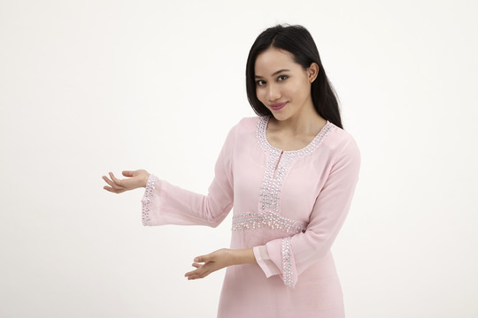 白色背景上有欢迎标志的马来妇女与baju kurung