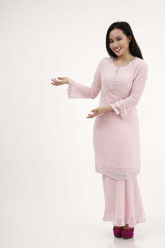 白色背景上有欢迎标志的马来妇女与baju kurung