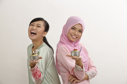 两名手持油灯或佩利塔的马来妇女