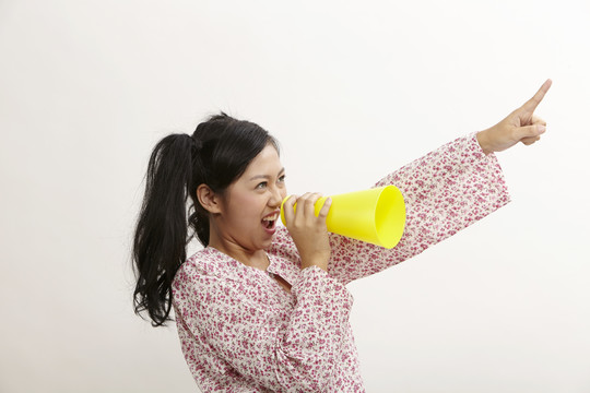 一名马来妇女拿着一个大电话大喊