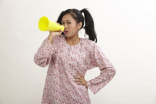 一名马来妇女拿着一个大电话大喊