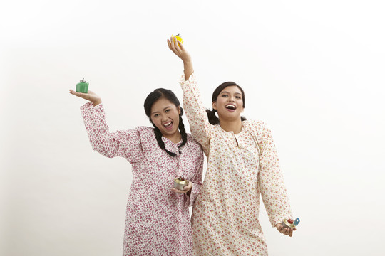 两名马来妇女身穿白底白衣，手持佩利塔